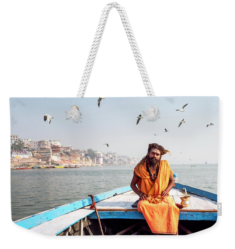 Asia Weekender Tote Bag featuring the photograph Sadhu in a boat. by Usha Peddamatham