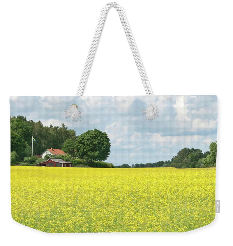 Field Weekender Tote Bag featuring the photograph Scandinavian summer landscape with yellow meadow by GoodMood Art