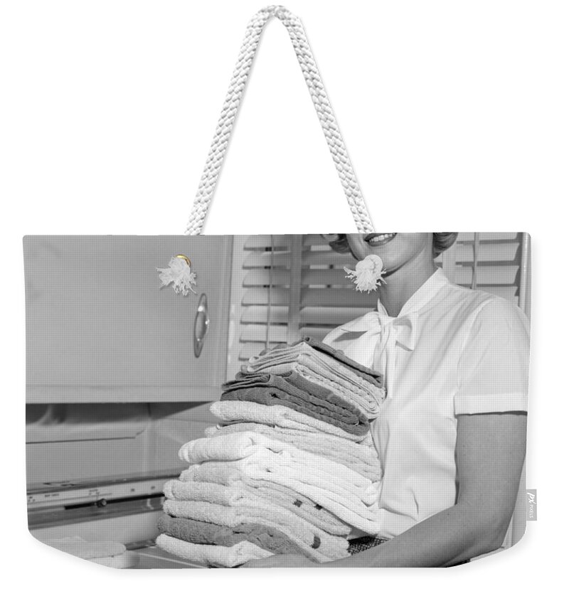1960s Weekender Tote Bag featuring the photograph Smiling Woman Holding Folded Laundry by H. Armstrong Roberts/ClassicStock
