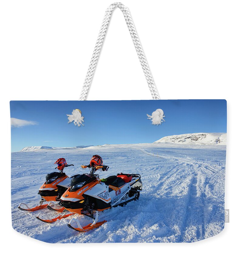 Snowmobile Weekender Tote Bag featuring the photograph Snowmobiles in Iceland in winter by Matthias Hauser