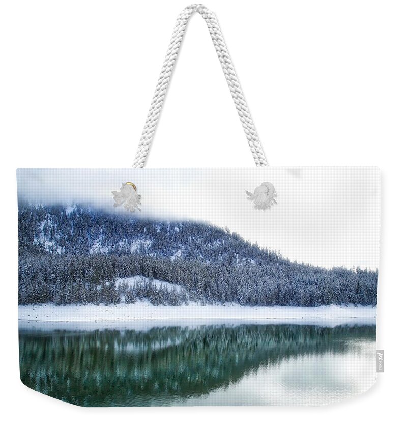 Snowy Trees On The Lake Weekender Tote Bag featuring the photograph Snowy trees on the lake by Lynn Hopwood