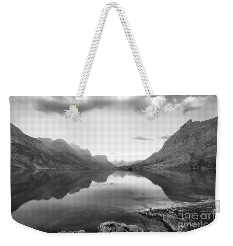 St Mary Lake Weekender Tote Bag featuring the photograph St Mary Lake Clouds And Calm Water Black And White by Adam Jewell