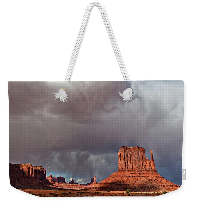 Desert Weekender Tote Bag featuring the photograph Storm over Monument Valley by Wesley Aston