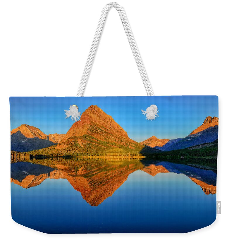 Swiftcurrent Lake Weekender Tote Bag featuring the photograph Swiftcurrent Morning Reflections by Greg Norrell