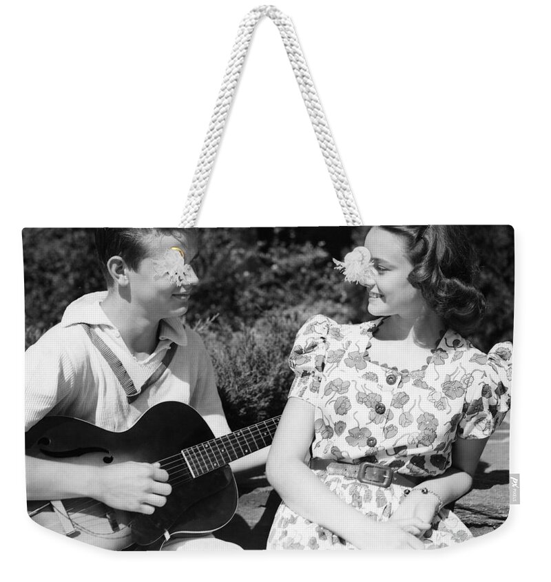 1940s Weekender Tote Bag featuring the photograph Teen Boy Serenading Girl With Guitar by H. Armstrong Roberts/ClassicStock