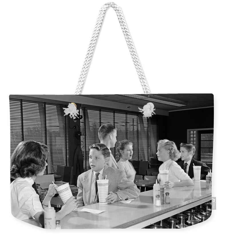 1950s Weekender Tote Bag featuring the photograph Teens At Soda Fountain, C.1950s by H. Armstrong Roberts/ClassicStock