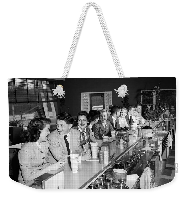 1950s Weekender Tote Bag featuring the photograph Teens At Soda Fountain Counter, C.1950s by H. Armstrong Roberts/ClassicStock