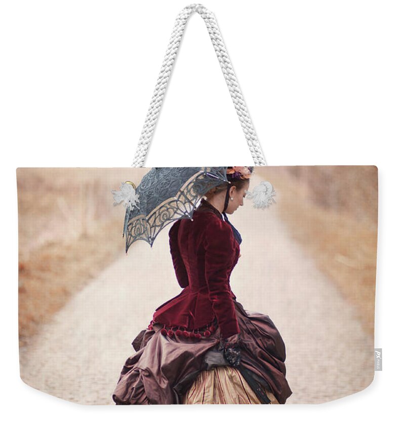 Victorian Weekender Tote Bag featuring the photograph Victorian Woman Alone On A Cobbled Path by Lee Avison