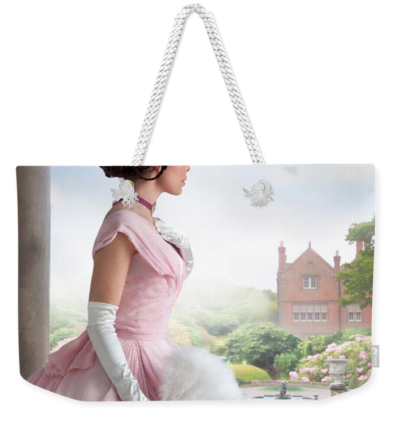 Victorian Weekender Tote Bag featuring the photograph Victorian woman in a ball dress in the garden by Lee Avison