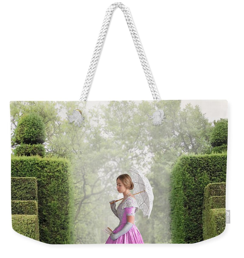 Victorian Weekender Tote Bag featuring the photograph Victorian Woman In A Pink Dress In The Garden by Lee Avison