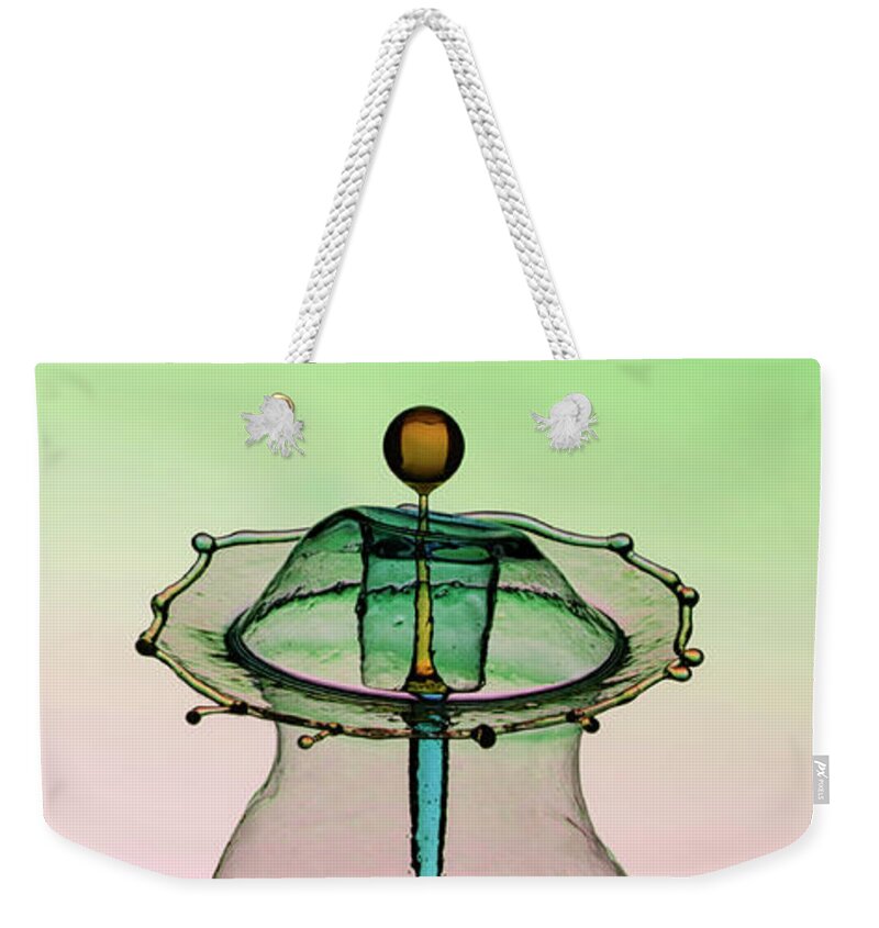Waterdrop Weekender Tote Bag featuring the photograph Water sculpture in green and blue colors by Jaroslaw Blaminsky