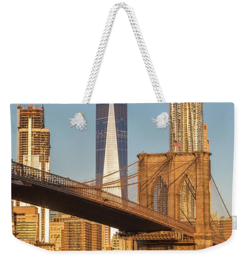 New York Weekender Tote Bag featuring the photograph Water Taxi and the Brooklyn Bridge by Jerry Fornarotto