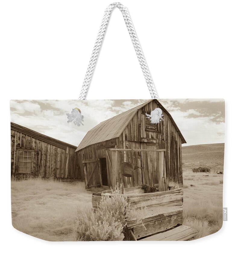 Abandoned Weekender Tote Bag featuring the photograph Well outside old barn in Bodie, California in sepia by Karen Foley