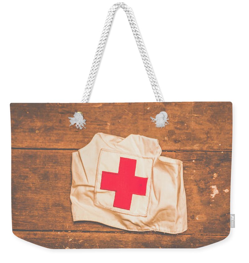 Nurse Weekender Tote Bag featuring the photograph WW2 nurse cap lying on wooden floor by Jorgo Photography