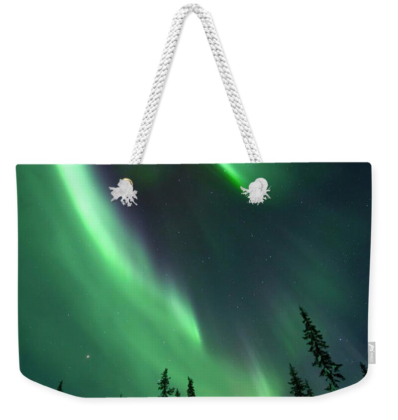 Extreme Terrain Weekender Tote Bag featuring the photograph Aurora Borealis Over A Frozen Forest #1 by Antonyspencer