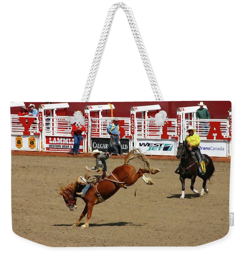 Canada Weekender Tote Bag featuring the photograph Cowboy on bucking bronco #1 by Steve Estvanik