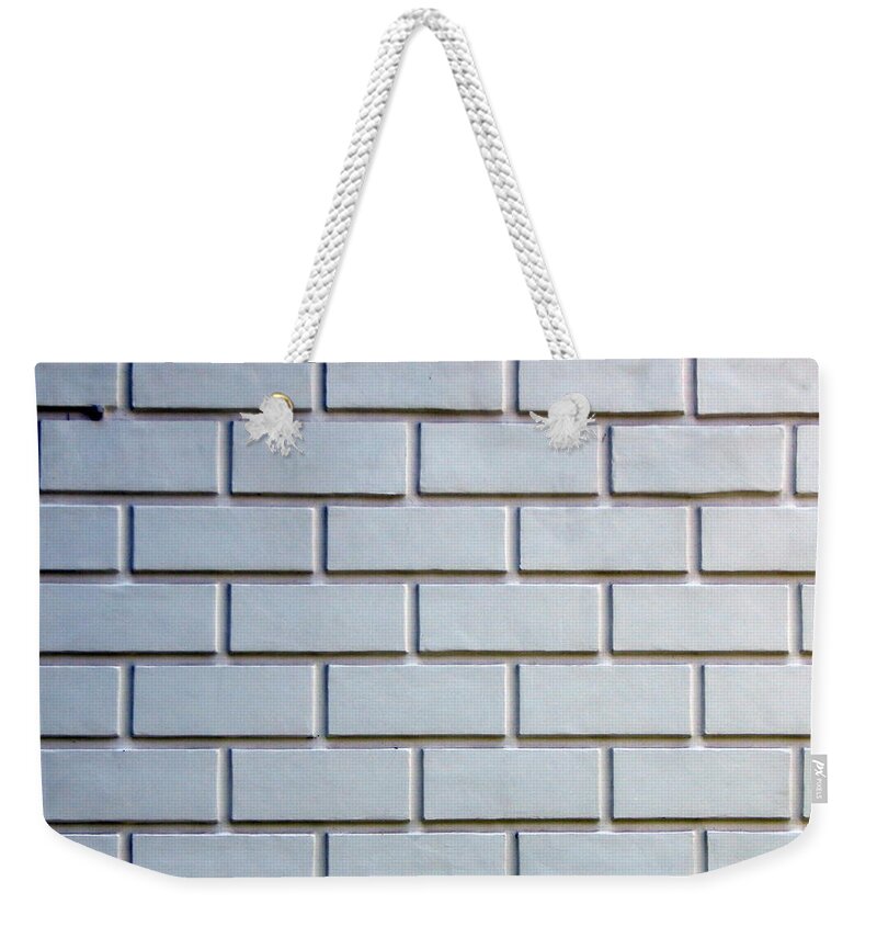 Stone Weekender Tote Bag featuring the photograph Texture of natural stone material and brick masonry walls #1 by Oleg Prokopenko