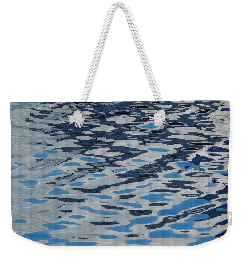 Water Weekender Tote Bag featuring the photograph Texture of water ripples on the surface of the river #1 by Oleg Prokopenko