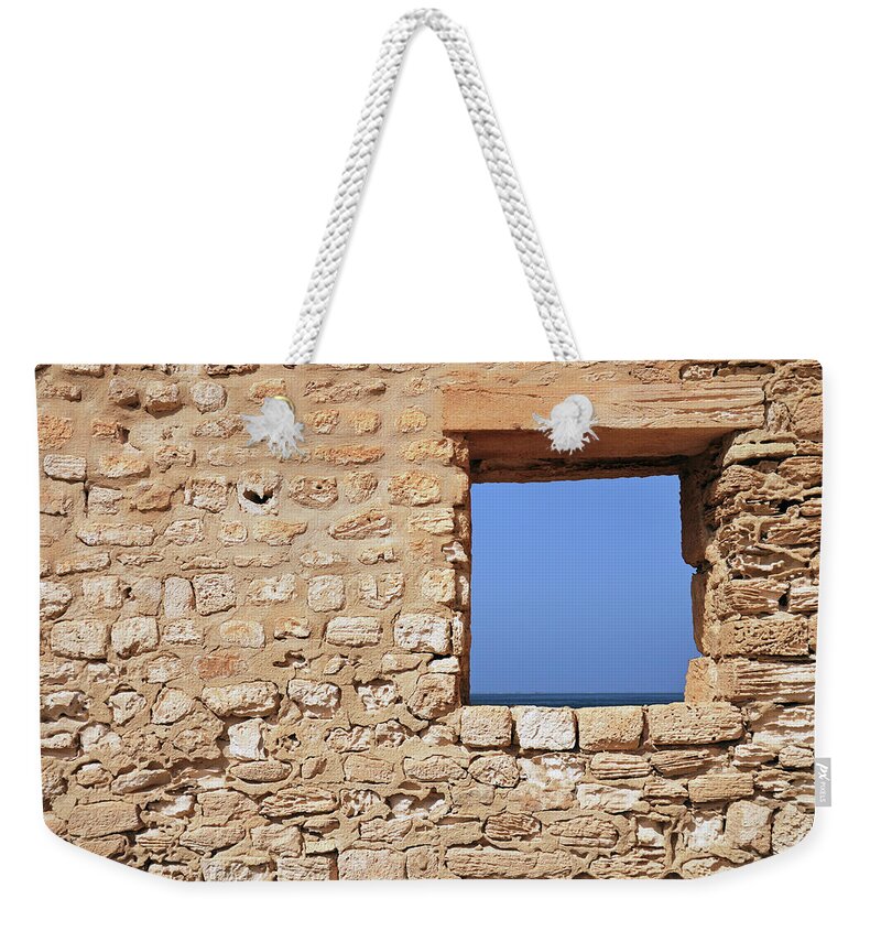 Tunisia Weekender Tote Bag featuring the photograph Wall With Window Framing Blue Seascape #1 by Sami Sarkis