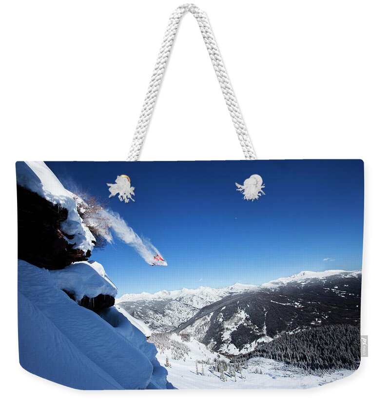 Scenics Weekender Tote Bag featuring the photograph A Snowboarder Jumps Off A Cliff Into by Patrick Orton