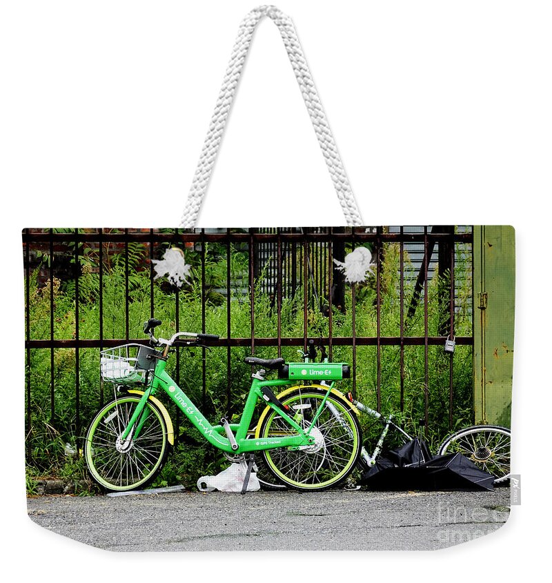 Electric-assist Bicycle Weekender Tote Bag featuring the photograph A Welcome Splash of Lime on a Wet and Windy Day by Steve Ember