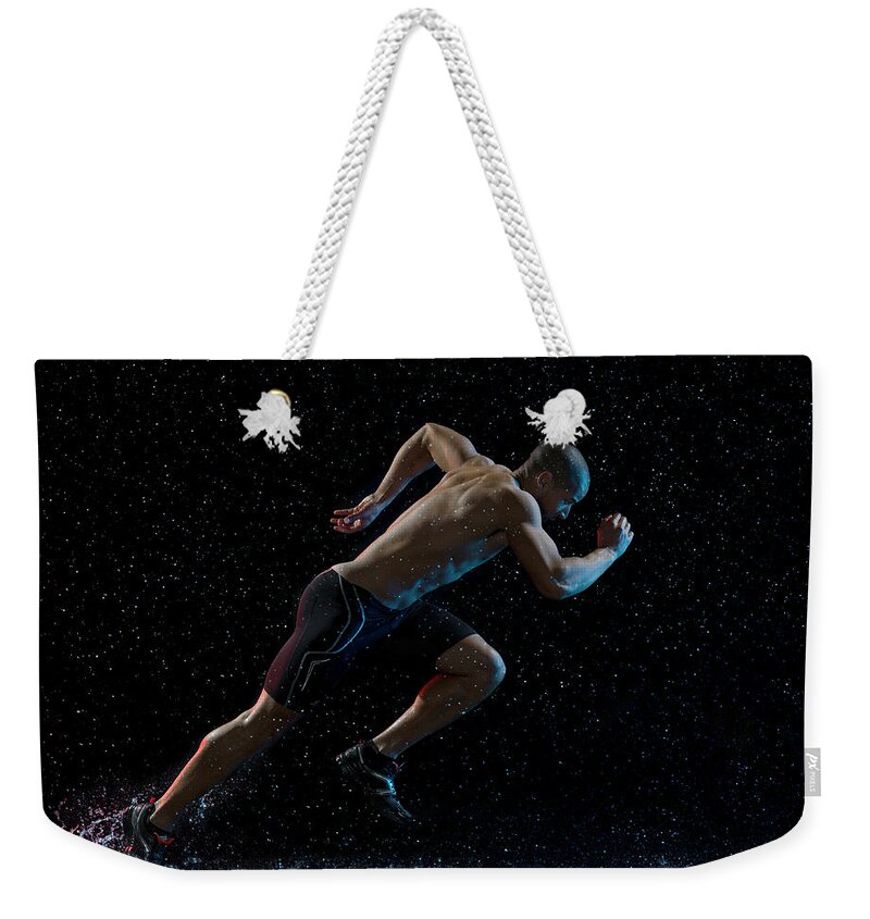 People Weekender Tote Bag featuring the photograph Athlete Runner Running Through Rain by Jonathan Knowles