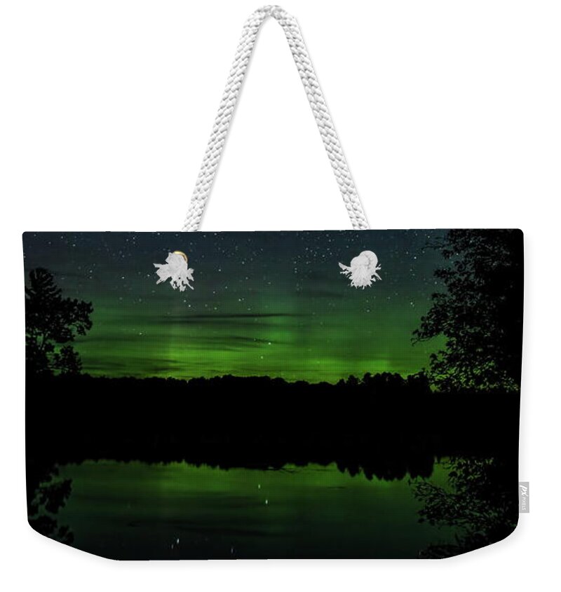 Aurora Borealis Weekender Tote Bag featuring the photograph Aurora Between The Trees by Dale Kauzlaric