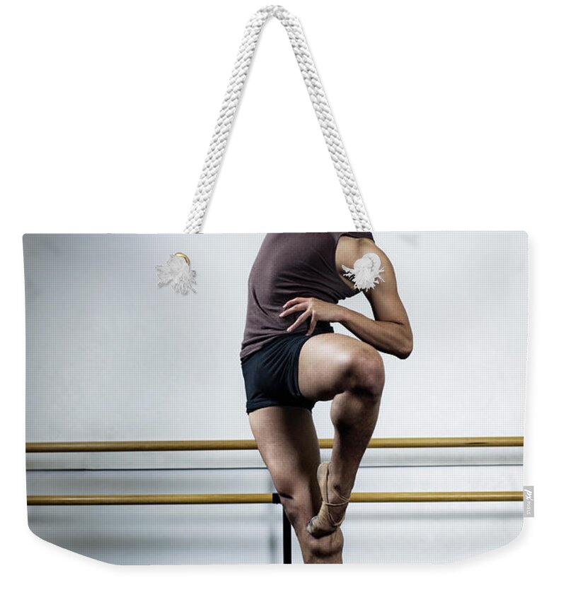 Ballet Dancer Weekender Tote Bag featuring the photograph Ballet Dancer Extending Arm While by Patrik Giardino