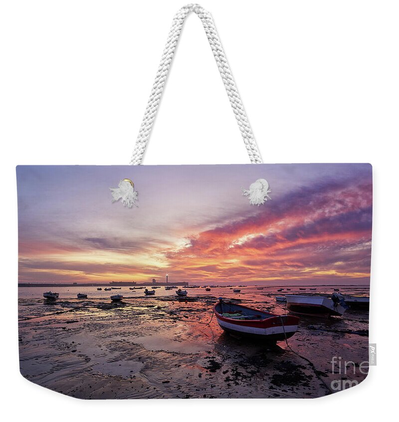 Shore Weekender Tote Bag featuring the photograph Boats at La Caleta Beach at Dusk under a Fiery Sky Cadiz by Pablo Avanzini