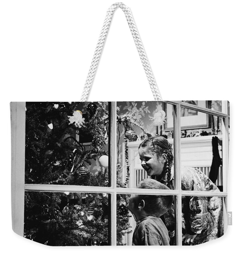 Child Weekender Tote Bag featuring the photograph Boy And Girl 3-8 Looking At Christmas by Fpg