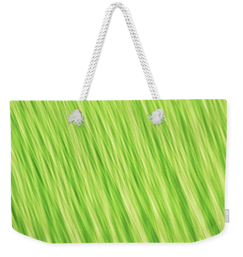 Abstract Weekender Tote Bag featuring the photograph Bright chartreuse green blurred diagonal lines abstract by Teri Virbickis