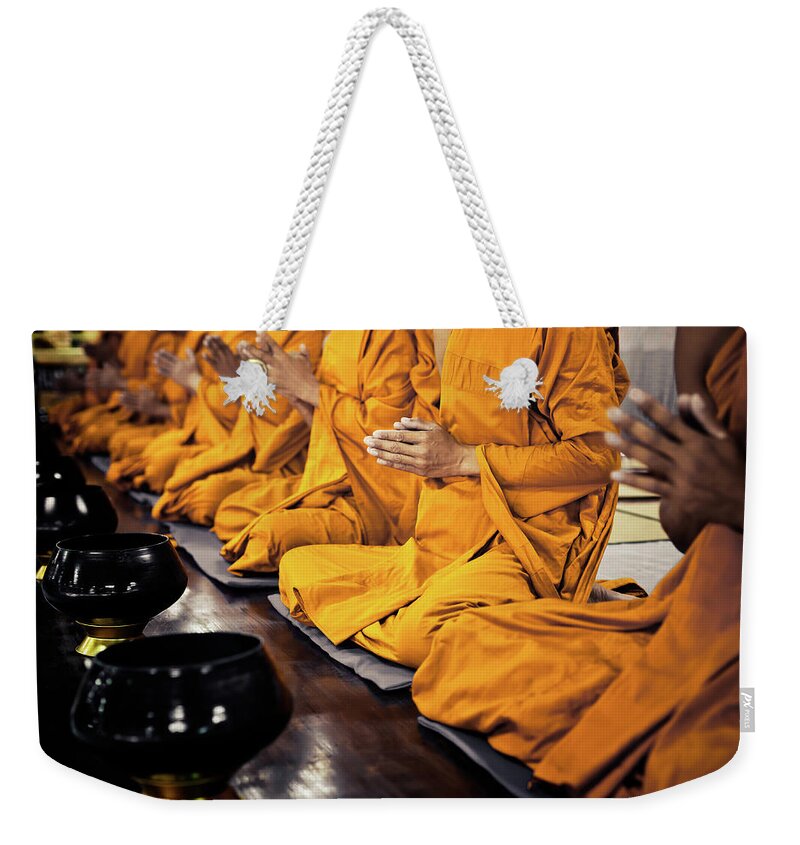 People Weekender Tote Bag featuring the photograph Buddhist Monks Praying by Fredfroese