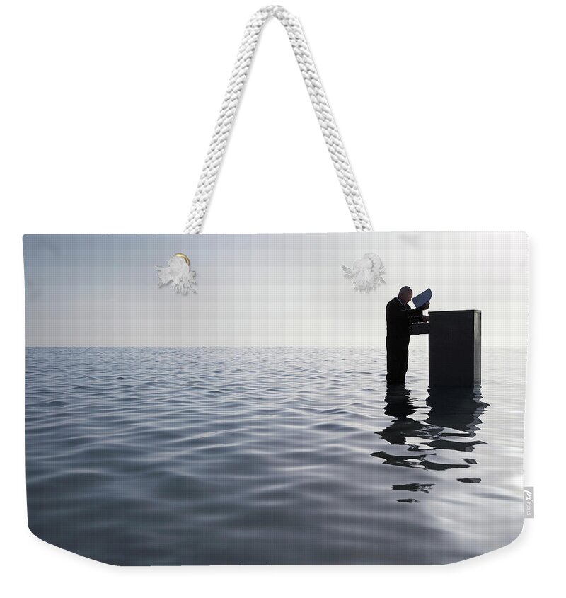 Mature Adult Weekender Tote Bag featuring the photograph Businessman Standing In The Ocean by Moodboard