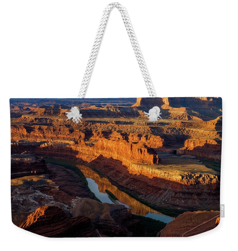 The Almost Full Moon Setting Over The Canyon At Dead Horse Point In Utah As The Sun Rose Lighting Up The Canyon Below. Weekender Tote Bag featuring the photograph Canyon Wall Reflection by Johnny Boyd