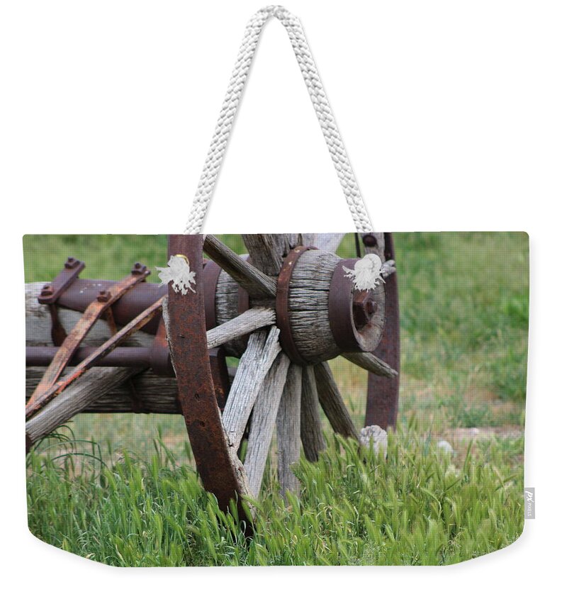 Wagon Wheel Weekender Tote Bag featuring the photograph Closeup Vintage Wooden Wagon Wheel in Grass by Colleen Cornelius