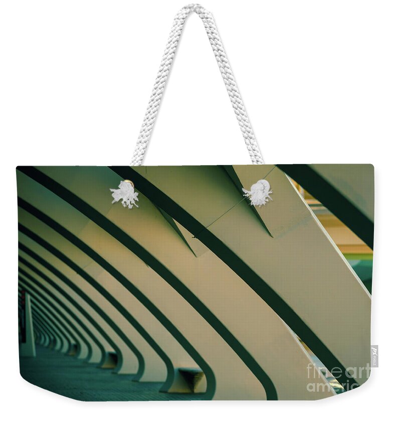 Abstract Weekender Tote Bag featuring the photograph Columns of white cement in a dark scene, as background of moder by Joaquin Corbalan