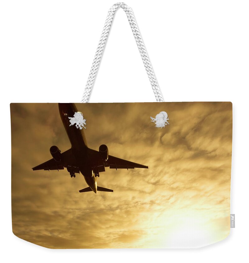 Dawn Weekender Tote Bag featuring the photograph Commercial Plane Landing by Greg Bajor