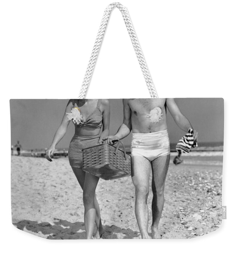 Heterosexual Couple Weekender Tote Bag featuring the photograph Couple Walking With Picnic Basket On by George Marks