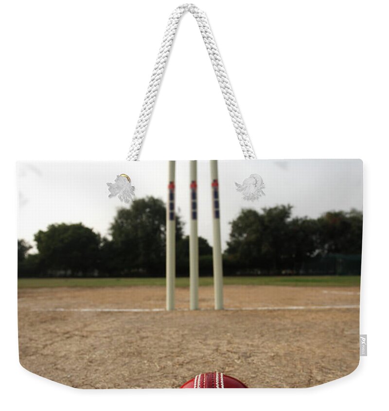 Shadow Weekender Tote Bag featuring the photograph Cricke Ball Aand Wickets On A Pitch by Visage