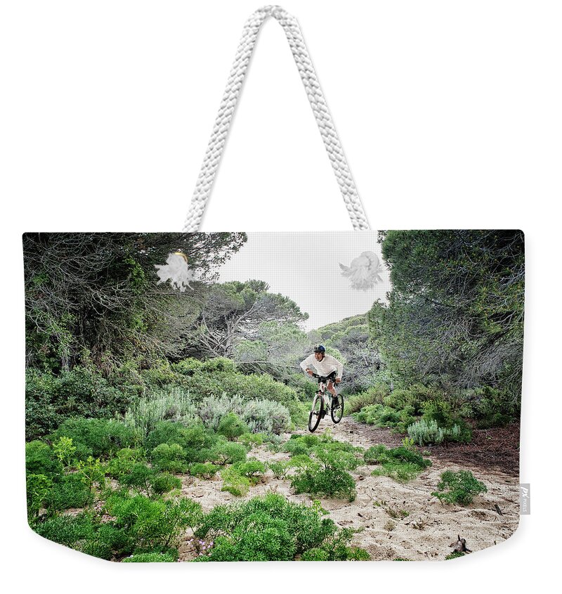 Sports Helmet Weekender Tote Bag featuring the photograph Cycling Over Rugged Terrain by Ben Welsh / Design Pics