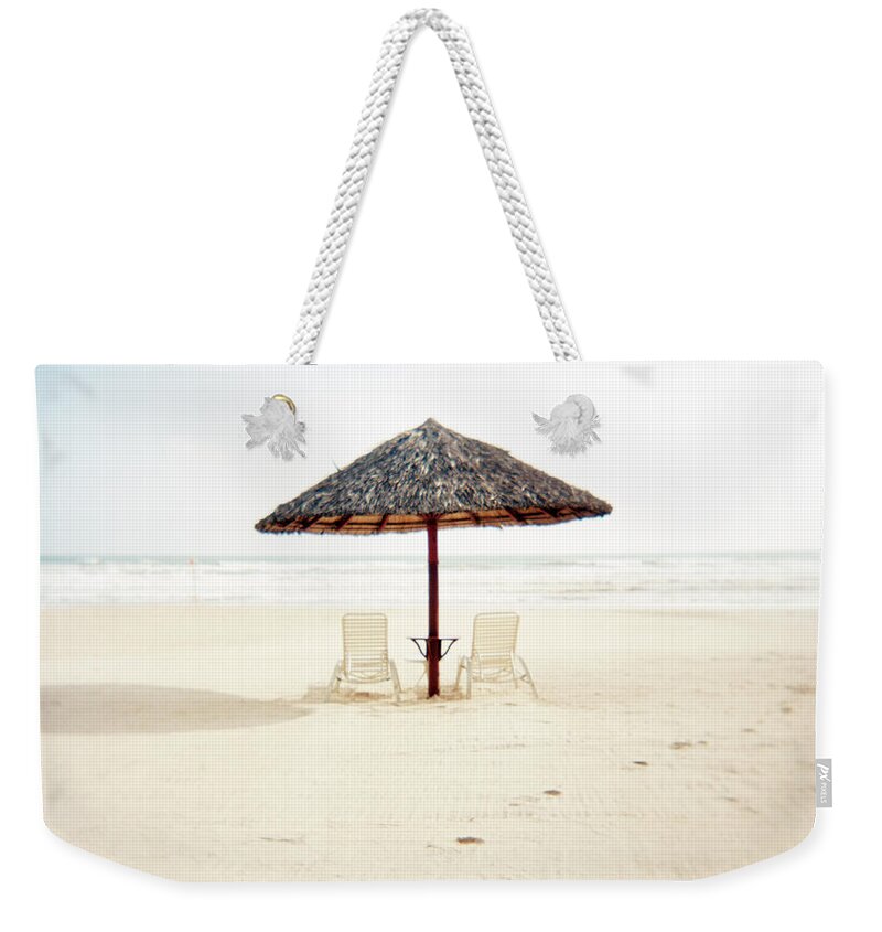 Scenics Weekender Tote Bag featuring the photograph Deckchairs With Bamboo Thatch Umbrella by Xpacifica