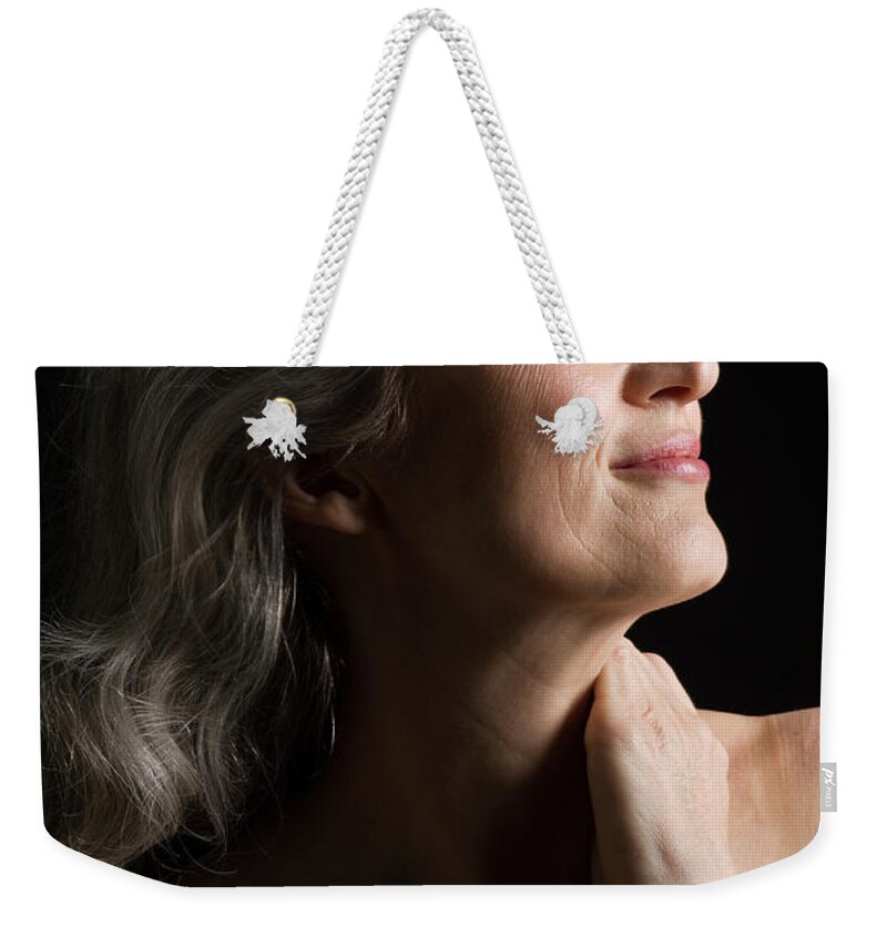 Mature Adult Weekender Tote Bag featuring the photograph Dramatic Portrait Of Mid-aged Woman by Leland Bobbe