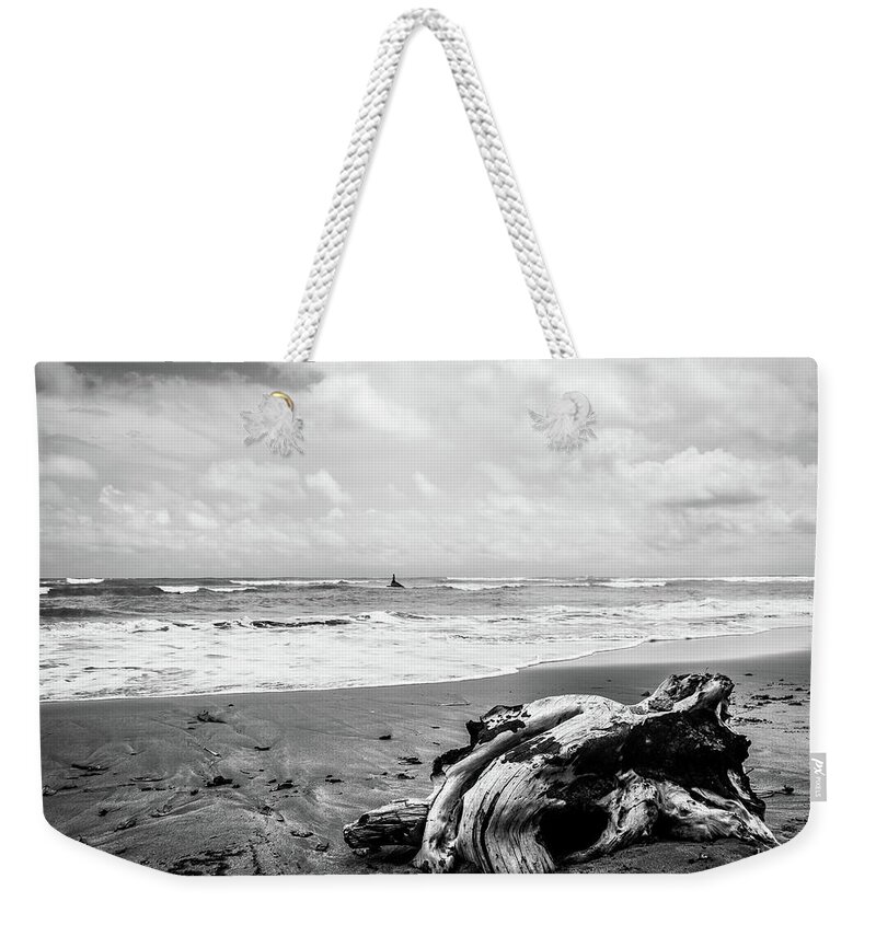 Water's Edge Weekender Tote Bag featuring the photograph Driftwood on Beach in Black and White by Tito Slack