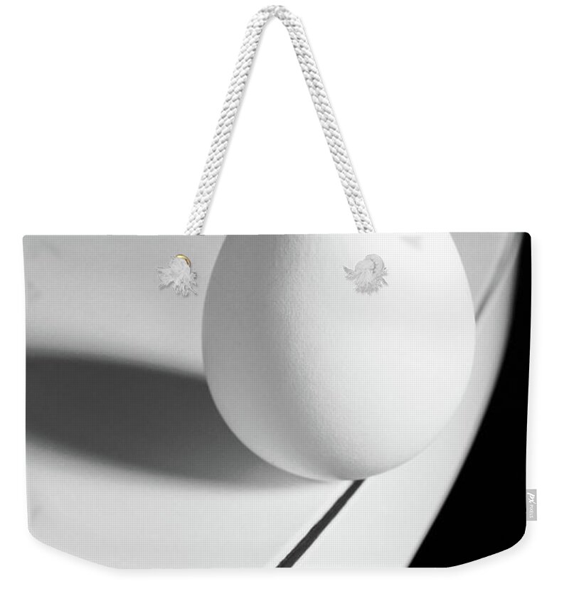 Corporate Business Weekender Tote Bag featuring the photograph Egg Carefully Balancing At The Edge Of by Scotspencer