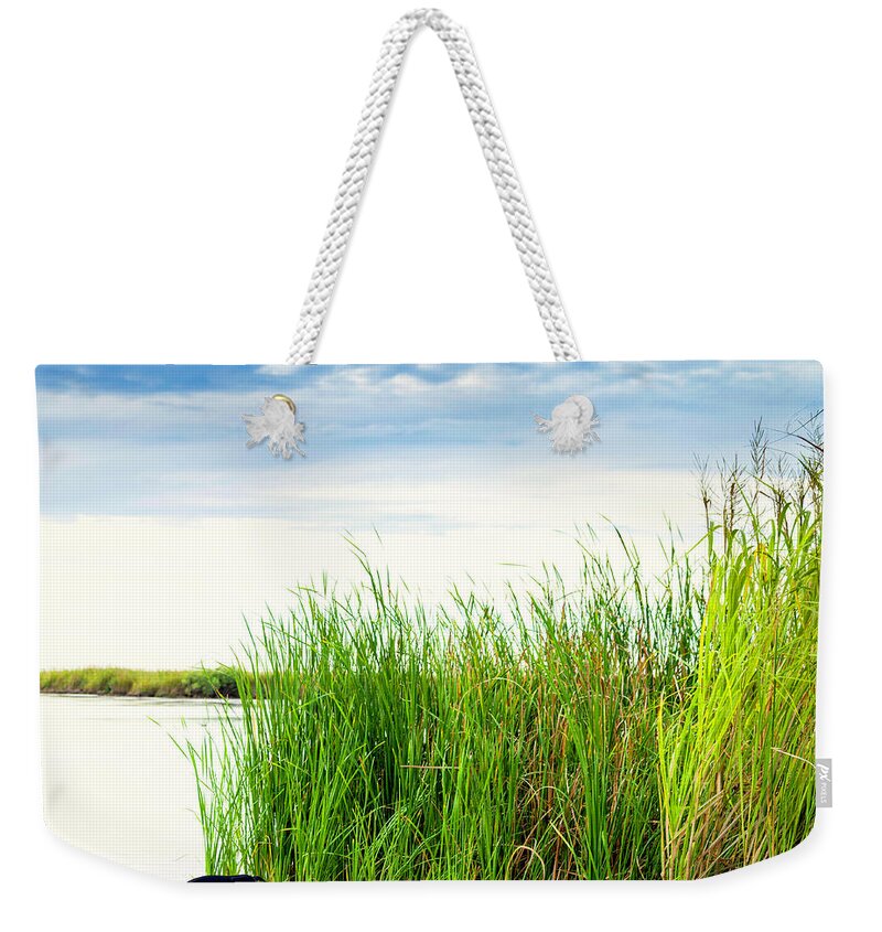 Scenics Weekender Tote Bag featuring the photograph Empty Kayak Resting In Reeds by Catlane