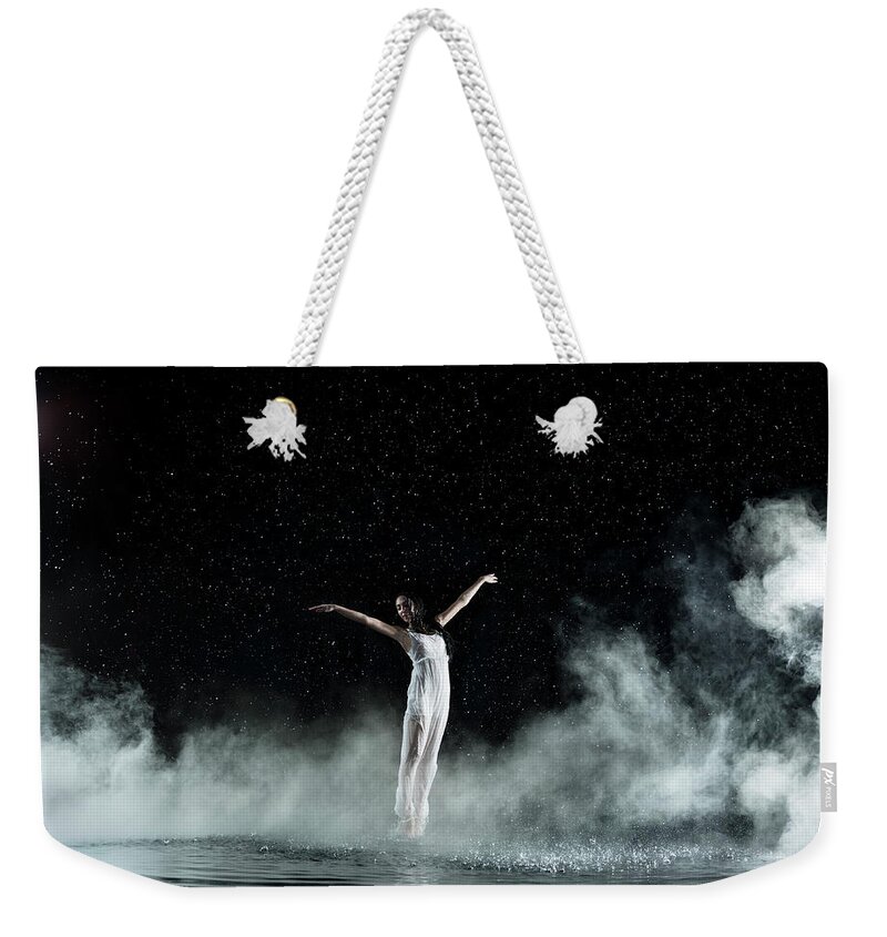 People Weekender Tote Bag featuring the photograph Female In White Dancing, Rainy Night by Jonathan Knowles