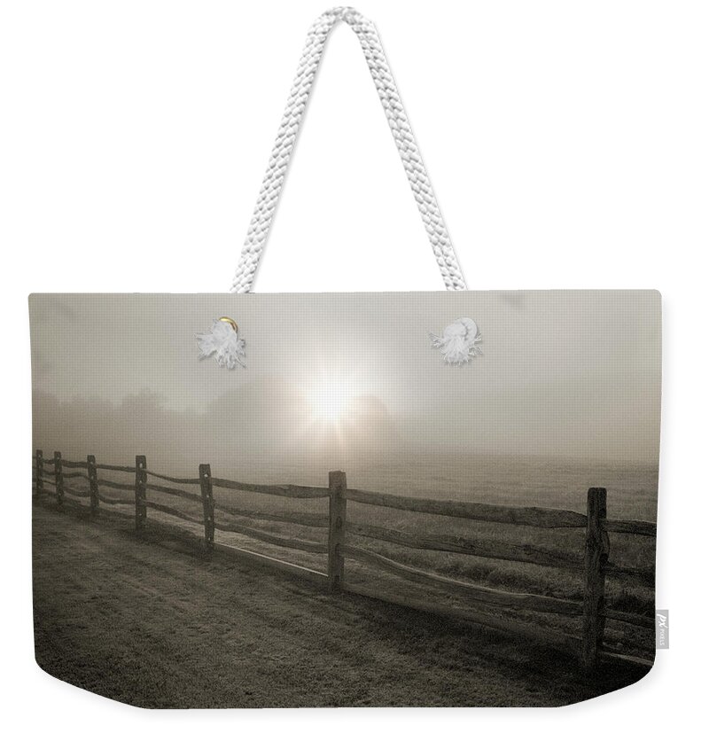 Tranquility Weekender Tote Bag featuring the photograph Fence And Sunburst Through Fog Near by Alvis Upitis