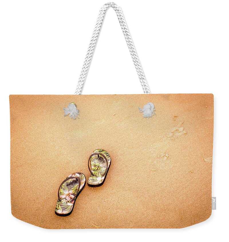 Beach Life Weekender Tote Bag featuring the photograph Flip-Flops On The Sand. by Jeff Sinon