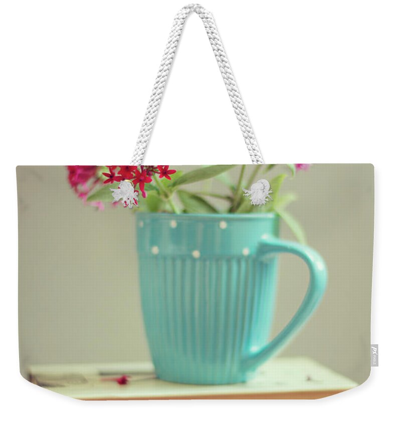 Close-up Weekender Tote Bag featuring the photograph Flowers In Blue Cup On Two Books by Copyright Anna Nemoy(xaomena)