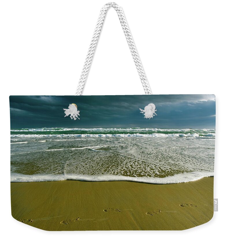 Water's Edge Weekender Tote Bag featuring the photograph Footsteps And Storm Light by Jill Ferry